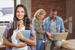 Portrait of smiling woman holding digital tablet