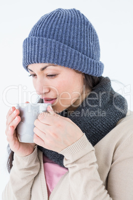 Smiling brunette drinking hot beverage