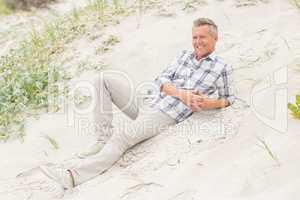 Smiling man lying on the sand