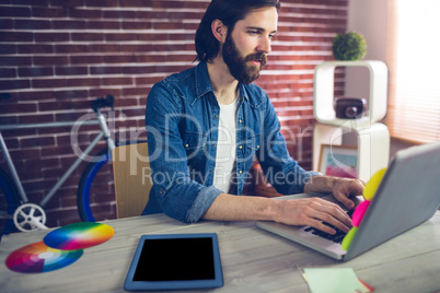 Creative businessman using using laptop by graphic tablet on des