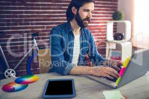 Creative businessman using using laptop by graphic tablet on des