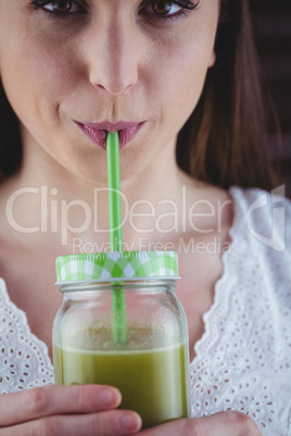 Pretty woman sipping on green juice