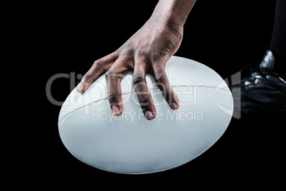 Cropped image of sportsman holding rugby ball