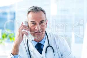 Male doctor talking on telephone in clinic