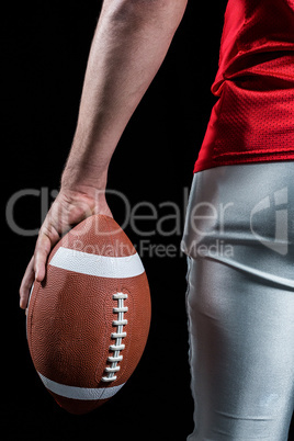 Cropped image of American football player holding ball