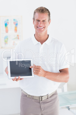 Smiling doctor showing laptop pc