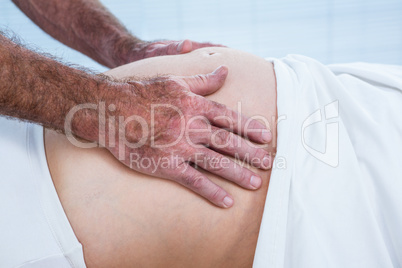 Close-up of therapist massaging belly of pregnant woman