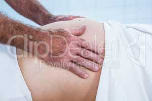 Close-up of therapist massaging belly of pregnant woman