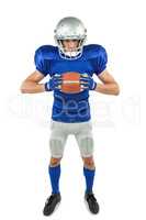 Full length portrait of American football player holding ball