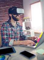 Creative businessman using 3D video glasses and laptop