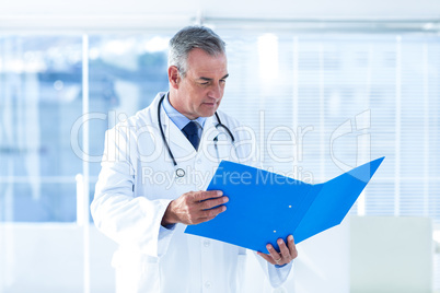 Male doctor reading document in hospital