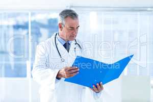 Male doctor reading document in hospital