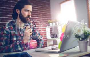 Thoughtful businessman using laptop