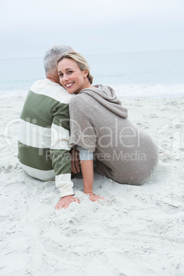 Cute couple sitting in the sand