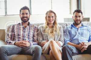Portrait of happy business people sitting on sofa