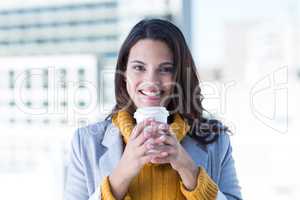 Smiling beautiful brunette drinking coffee