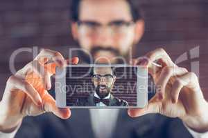 Portrait of man in cellphone taking selfie