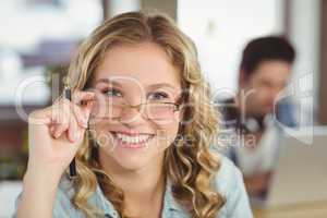 Beautiful smiling businesswoman holding eye glasses in office