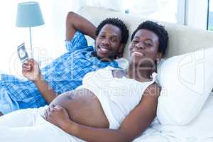 Smiling relaxed couple lying on bed