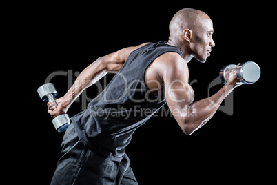 Muscular man running while holding dumbbell