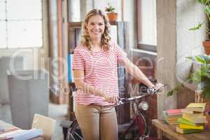 Portrait of businesswoman with bicycle in office