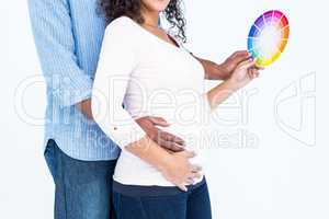 Midsection husband with wife holding color wheel