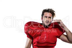 Wet American football player in red jersey looking away