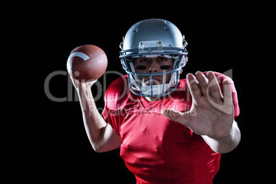 Portrait of sportsman defending while holding American football