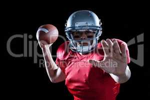 Portrait of sportsman defending while holding American football