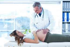 Male doctor examining pregnant woman in clinic