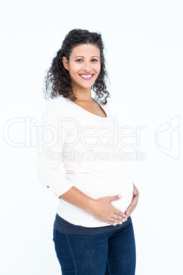 Portrait of happy pregnant woman touching abdomen