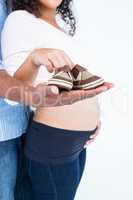 Man palm with shoes and pregnant wife