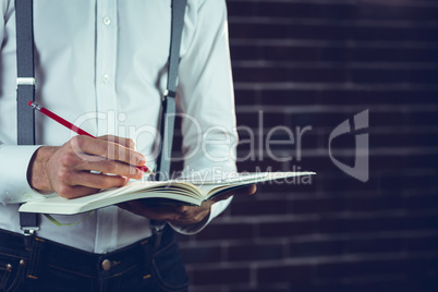 Businessman planning with help of smartphone and book