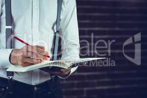 Businessman planning with help of smartphone and book