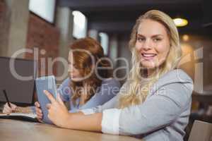 Portrait of young woman holding digital table