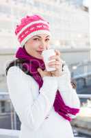 Smiling woman drinking from white cup