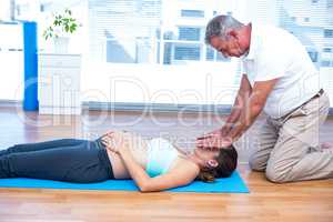 Therapist performing reiki on young woman