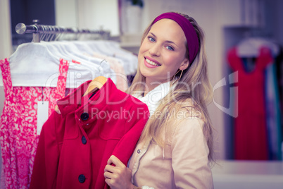 Smiling woman holding red coat