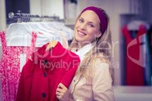 Smiling woman holding red coat