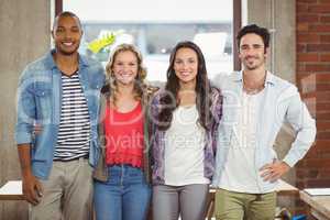 Business people standing with arms around creative office