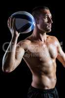 Serious shirtless sports player holding ball