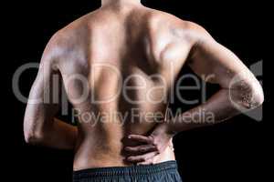 Rear view of shirtless man with back pain