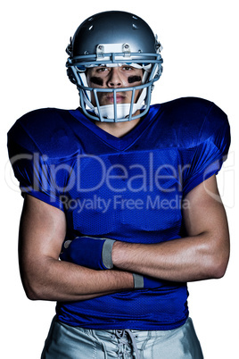 Portrait of determined American football player with arms crosse