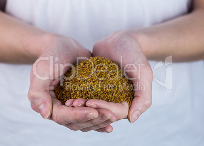 Woman showing handful of milled seed