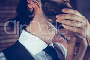 Man shaving beard with razor