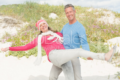 Smiling happy man carrying a woman