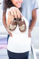 Pregnant woman showing shoe