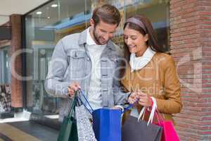 Young happy couple looking at shopping bags