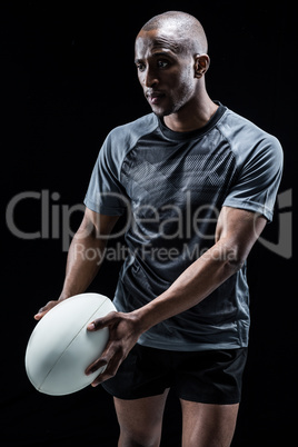 Thoughtful athlete with rugby ball