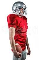 Serious American football player in red jersey looking away whil